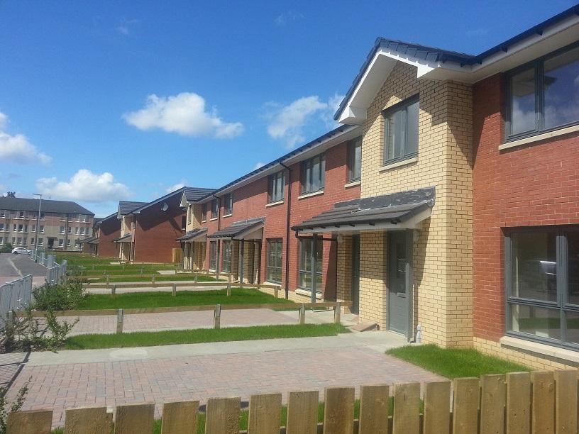 PIC - STOCK - row of houses with red and beige bricks plus blue sky